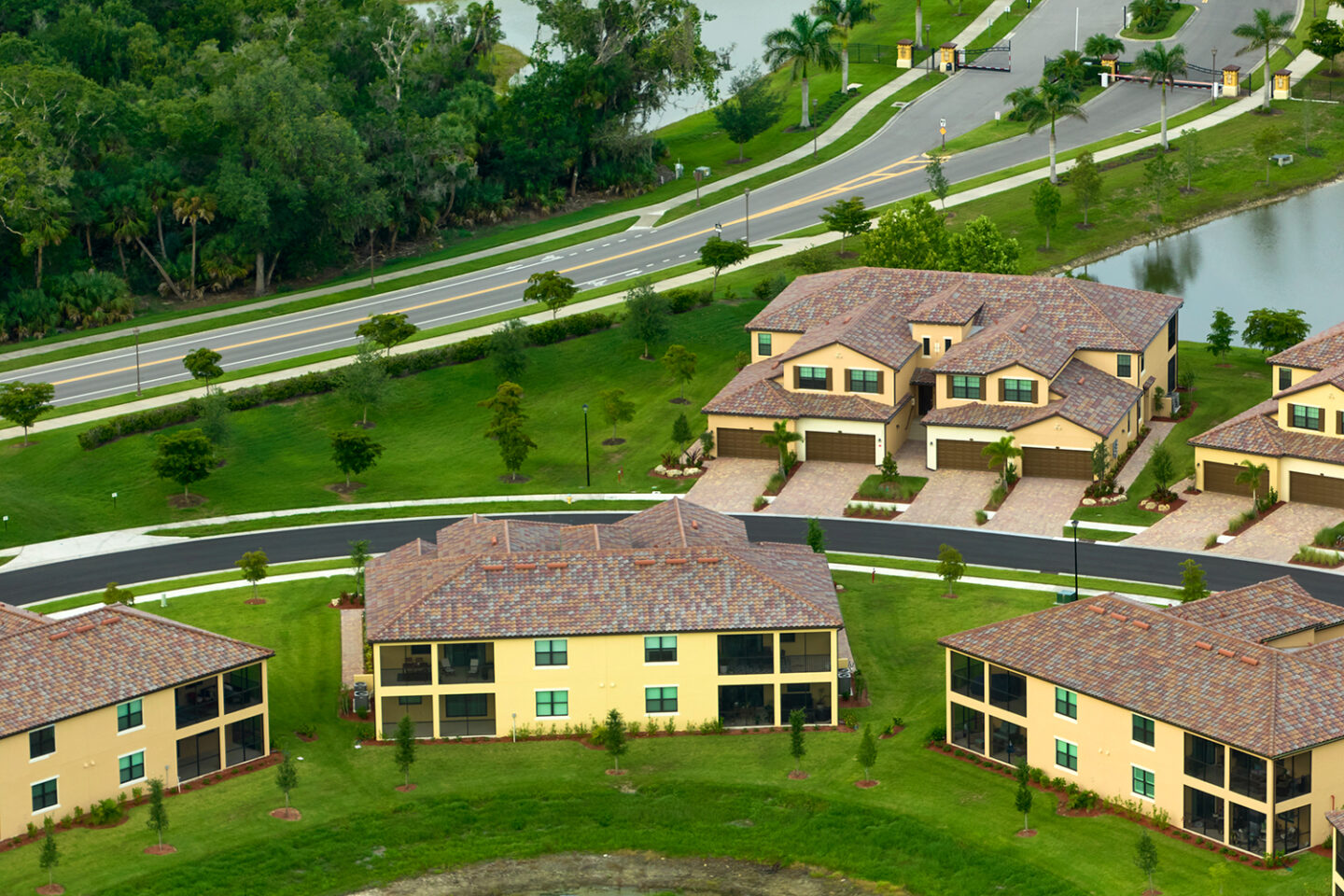 Aerial view of a picturesque residential neighborhood in east Tennessee, showcasing tan houses with tiled roofs, manicured lawns, and winding roads—an ideal snapshot for realty and property management interests.